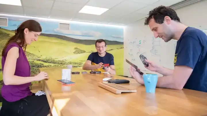 Atelier de conception : des collaborateurs d’Active Développement réunis autour d’une table, smartphones en main